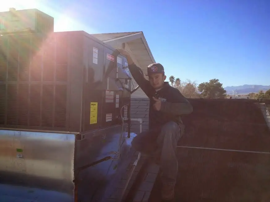 HVAC technician performing Heat Pump Repair on a rooftop unit in Del City